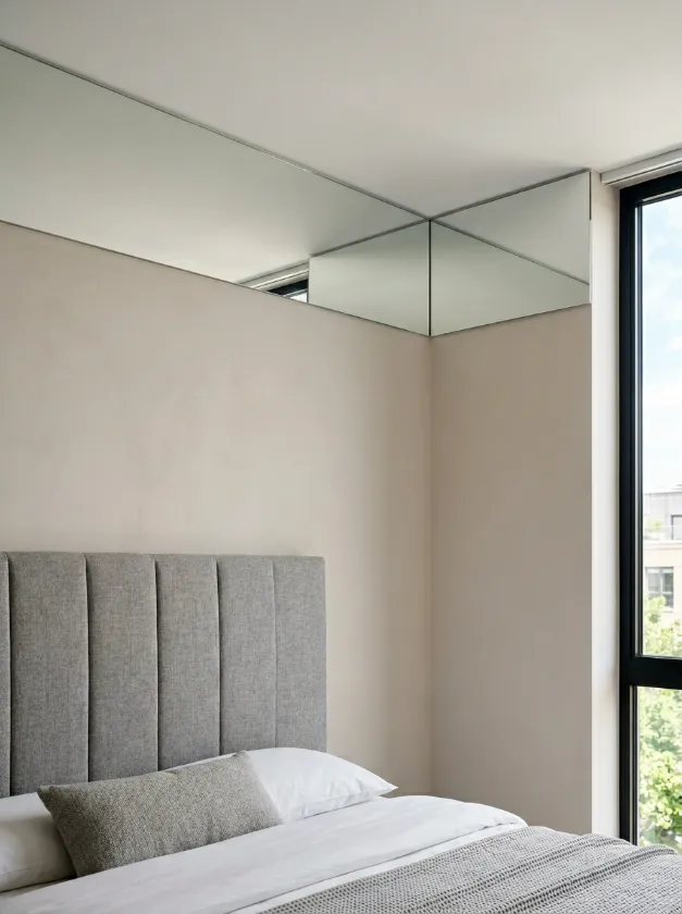 Reflective mirror strips installed at the ceiling and wall junction.
