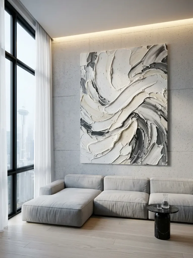 Massive Abstract Canvas Art Large square canvas with thick swirling white and gray paint hanging over a light gray sofa.