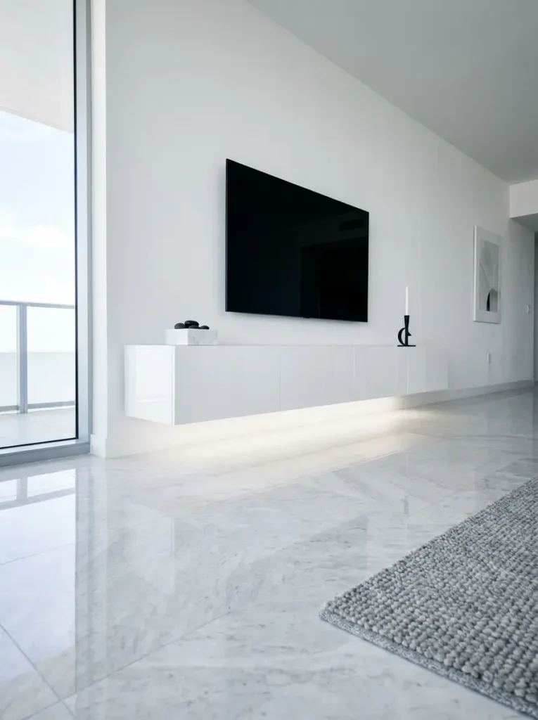Sleek white floating console with LED under lighting creates a minimalist small living room tv wall.