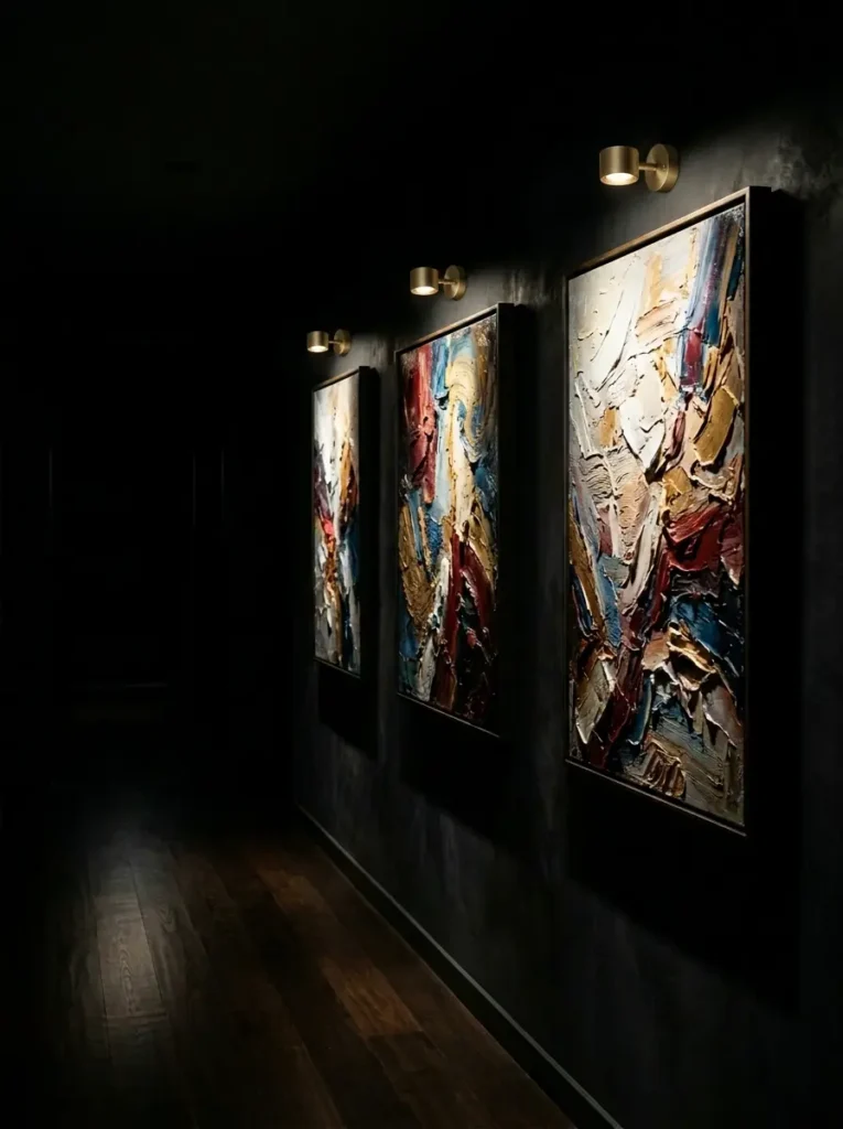 Brass art sconces shining on textured paintings to improve lighting for dark apartments.