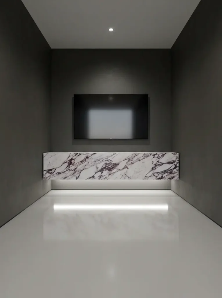 Floating Marble TV Console Floating marble cabinet mounted under a flat television on a dark gray wall with glossy floors.