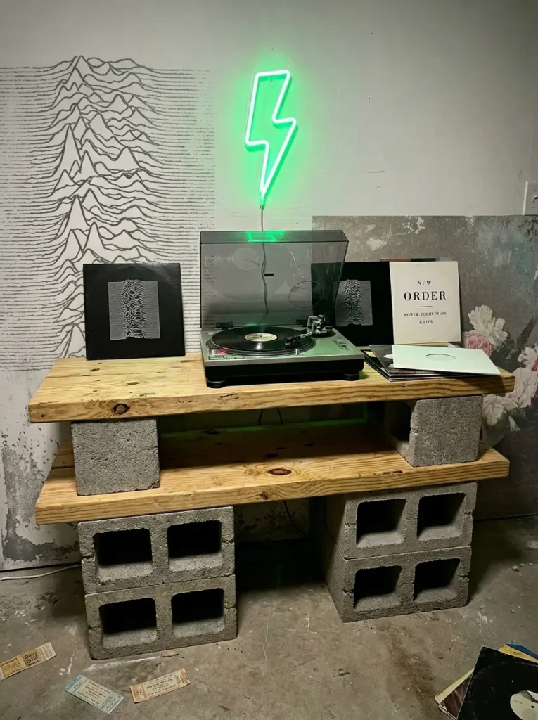 DIY media console made from stacked grey cinder blocks and raw pine wooden planks