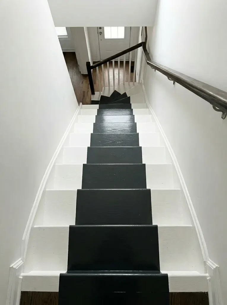 Painted Faux Stair Runner | StylishGalore Wooden staircase painted white with a continuous glossy black stripe running down the center