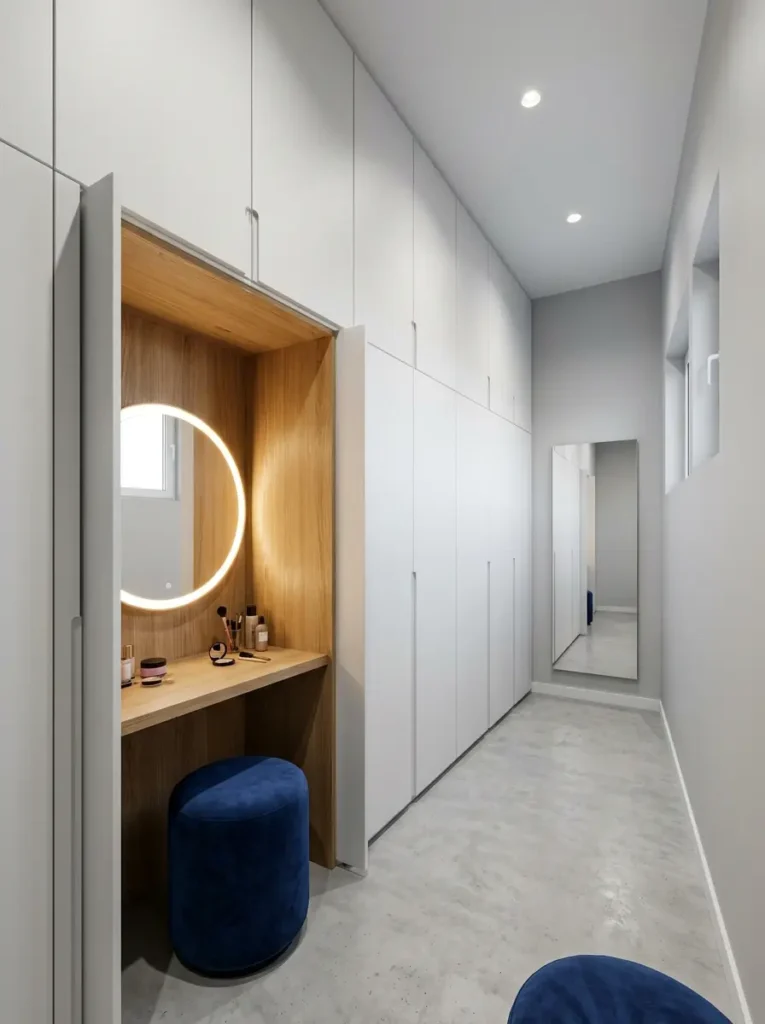 White modular wardrobe with a hidden oak wood vanity section pulled out in a narrow dressing room.