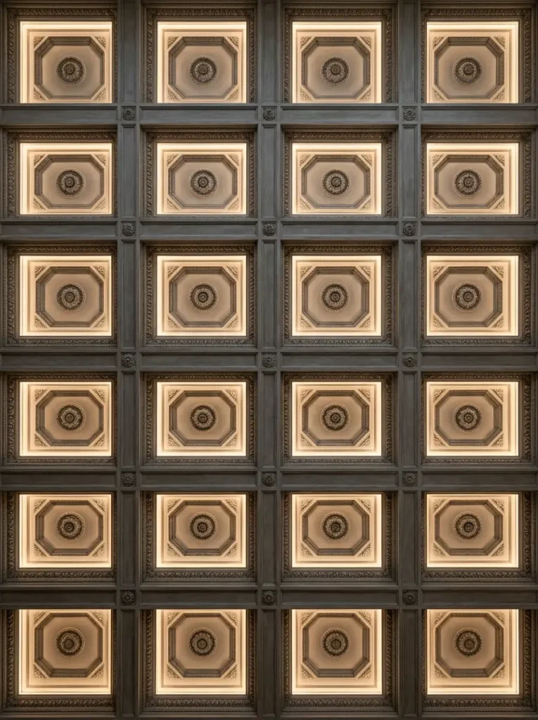 Deep square wooden ceiling coffers featuring hidden lighting and central rosettes