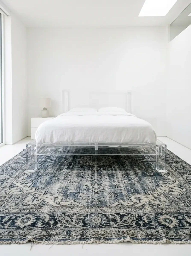 Clear lucite bed frame in bright bedroom