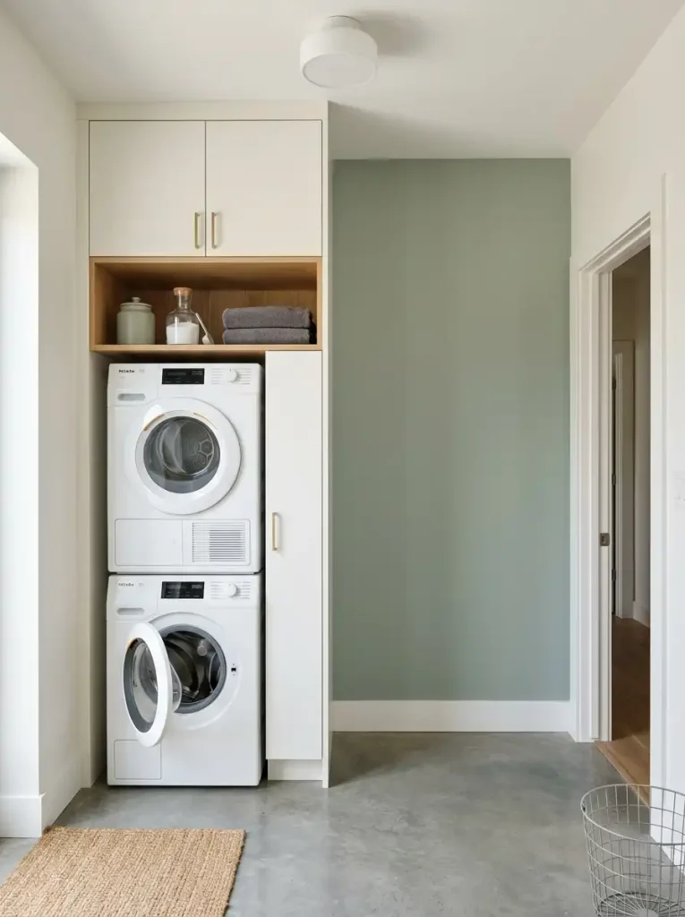 Compact laundry area with vertical storage concentrated in one zone and open wall space beside it.