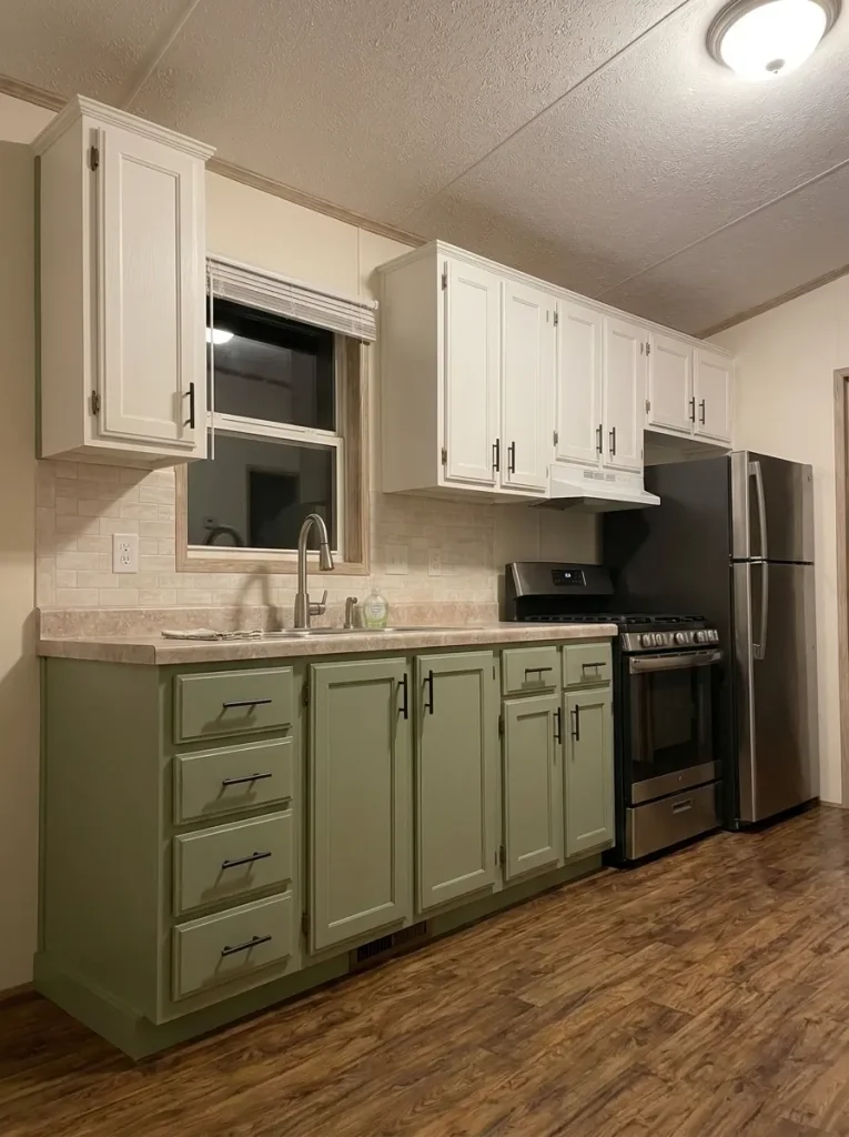 Low-angle view of sage mobile-home cabinets with matching toe kicks, exposed ends and trim completing the refresh.