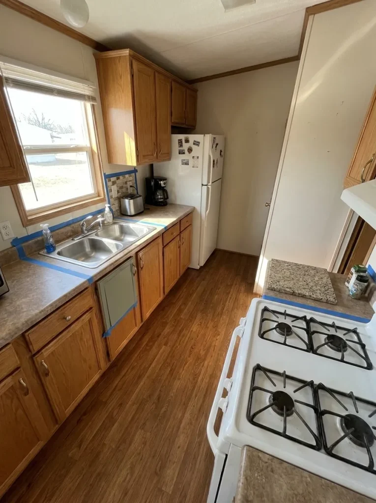 Mobile-home kitchen with cabinet, backsplash and countertop samples showing how each upgrade connects to different surrounding elements.