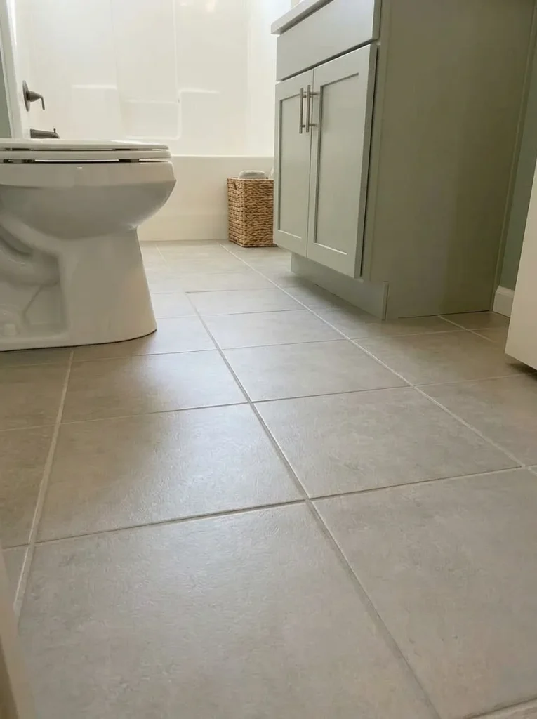 Clear floor and toe approach beneath a compact vanity in a narrow single-wide bathroom.
