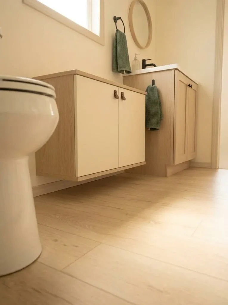 Shallow floating bathroom cabinet preserving visible floor in a compact manufactured-home bathroom.