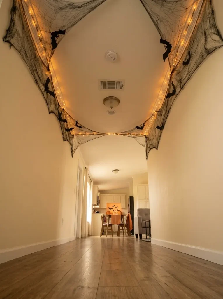 Narrow mobile home hallway with lightweight Halloween webbing, bats and warm lights arranged safely across part of the ceiling.