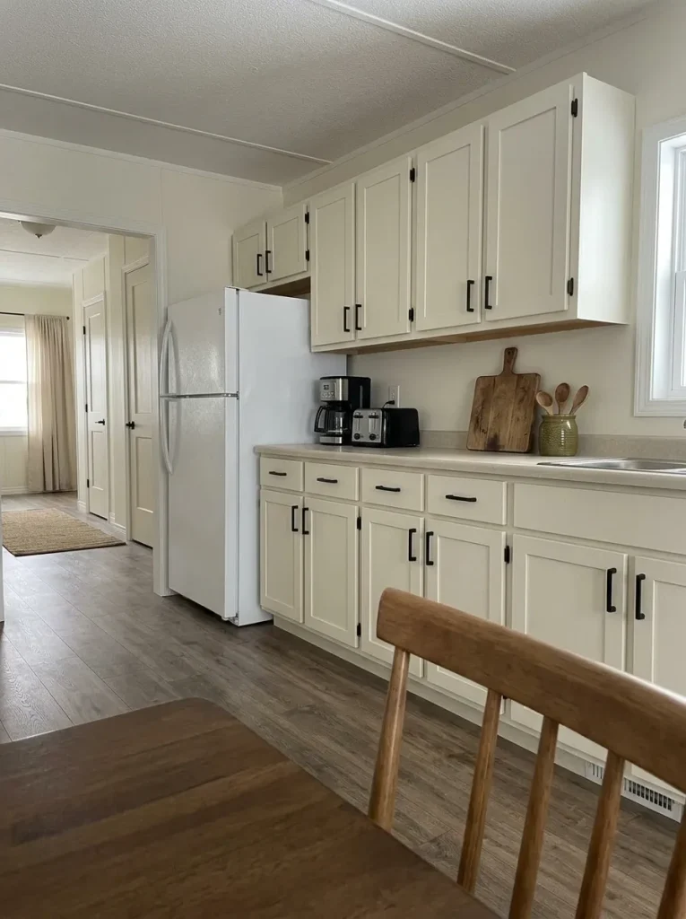 Mobile home kitchen elevation with uncluttered counters, coordinated hardware and simple budget-friendly styling.