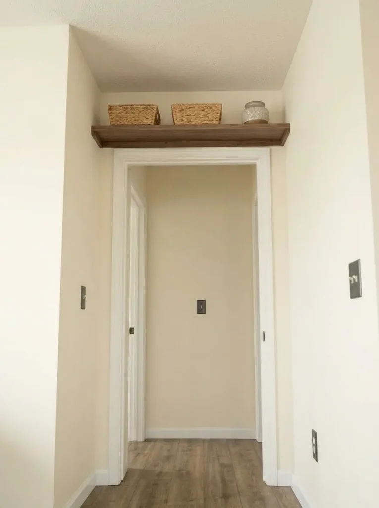 Shallow DIY shelf above an interior door stores lightweight items without using floor space.