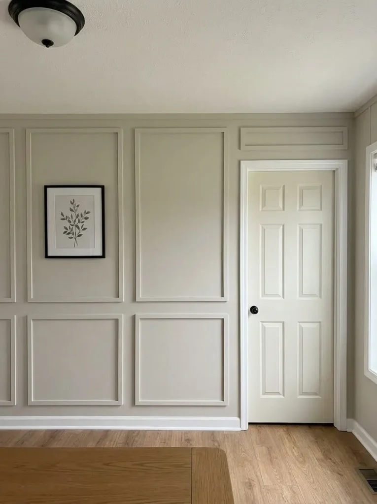 Compact mobile home wall with large same-color picture-frame molding arranged around an existing doorway.