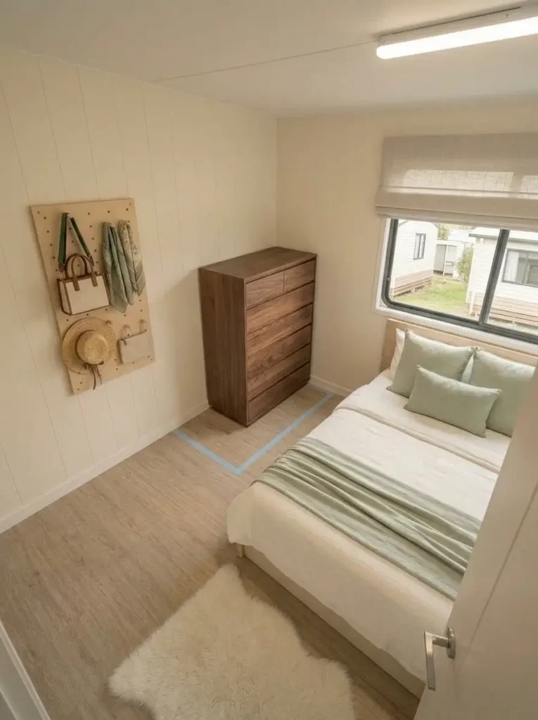 Tall shallow dresser freeing a wider walking route beside the bed in a compact mobile home bedroom.