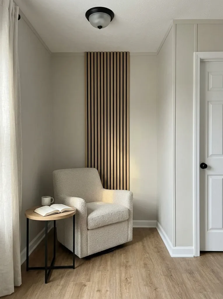 Narrow natural-oak slat field behind a reading chair in a compact mobile home living room.
