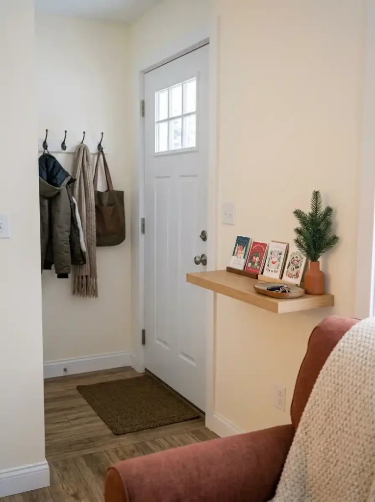 Christmas cards and a key tray share a narrow entry shelf beside an unobstructed mobile home entrance.