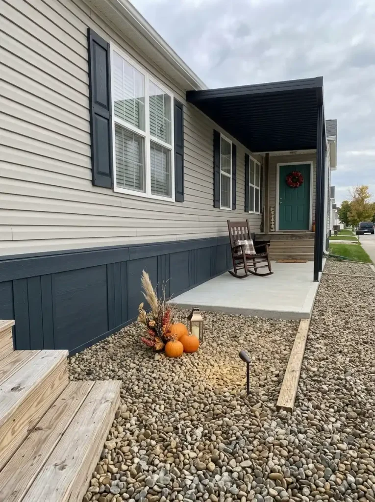 Decluttered manufactured-home porch with a clear walking area and one focused Halloween display near the entry.