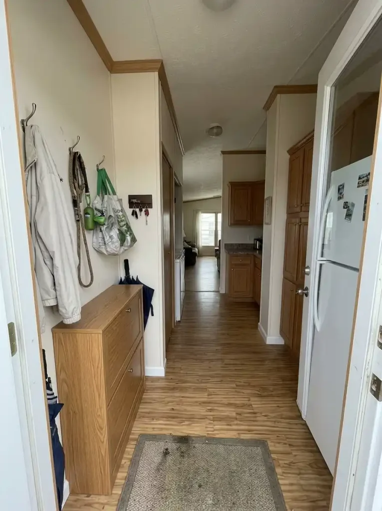 Secondary single-wide entry with compact storage for outdoor shoes, reusable bags and pet items beside a clear doorway.